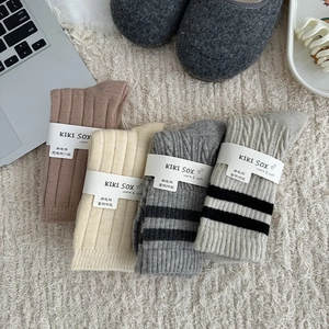 Detailed knit texture and striped pattern of thick wool socks in varied neutral colors