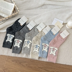 Detail of six pairs of knit crew socks with cartoon bear patterns and polka dots