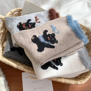 Detail of wool socks with fluffy faux fur cuffs and cute embroidered bear patterns