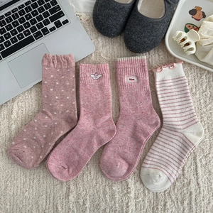 Detailed close-up of 4-pack pink wool socks with ruffles, polka dots, and stripes