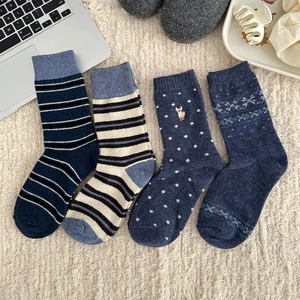 Detailed knit patterns of thick winter wool socks with stripes and elk embroidery