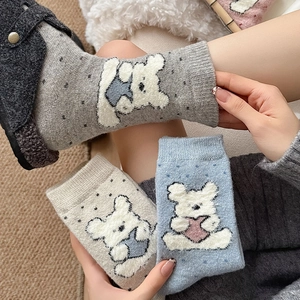 Detail of plush bear pattern and rib knit cuffs on thick warm cartoon crew socks