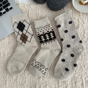 Detailed knit patterns of thick wool socks featuring Nordic trees and diamond argyle