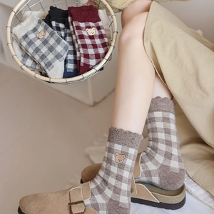 Detailed close-up of plaid patterns and brown bear embroidery on thick winter socks
