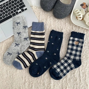 Detail of four pairs of warm winter wool socks with patterns on a soft rug