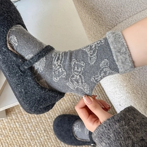 Detail of gray wool socks showing elastic cuff with cute white bear jacquard pattern