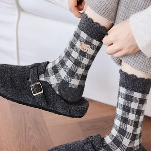 Detail of grey checkered crew socks with bear embroidery and frill trim edges