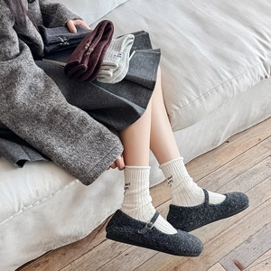 Detail of wool-blend ribbed socks featuring elegant heel embroidery and rolled cuffs