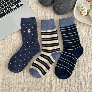 Three pairs of warm wool socks with navy stripes, polka dots, and animal embroidery