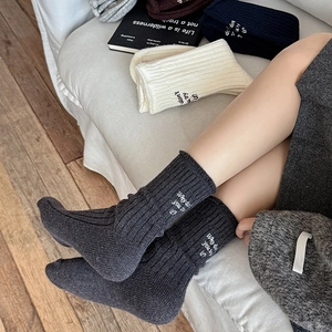 Detail of wool blend thermal socks with elegant heel embroidery and ribbed knit texture
