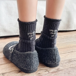 Close-up of wool socks with white letter embroidery 'Why don't you try it?' on the heel