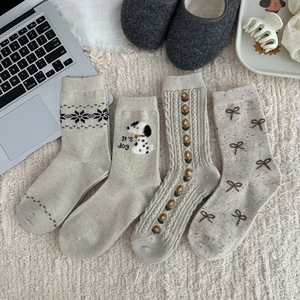 Detail of wool socks featuring Nordic snowflake patterns and cute puppy embroidery