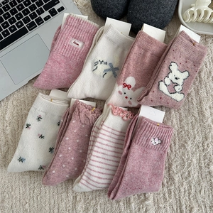 Flat lay of pink and beige floral wool socks set on cozy plush rug with home decor