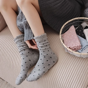 Detail of ruffled cuffs and polka dot pattern on warm knitted wool crew socks