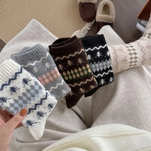 Dettaglio calze in misto lana Fair Isle con motivi festivi di alberi e losanghe a maglia