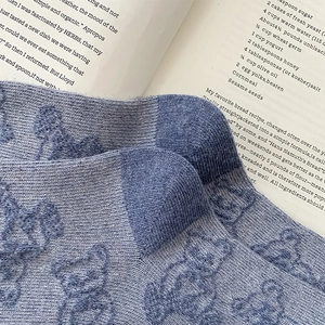 Macro shot of blue wool socks with embossed bear pattern and contrasting knit texture