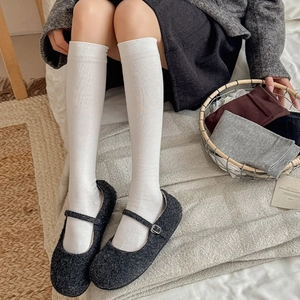 Vertical ribbed texture of white knee-high socks paired with stylish Mary Jane shoes