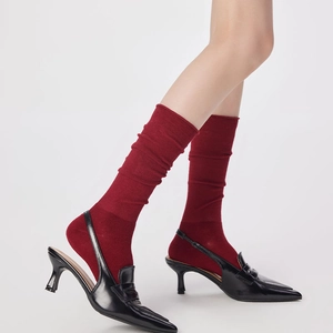 Détail de chaussettes en laine rouge foncé avec des talons aiguilles noirs