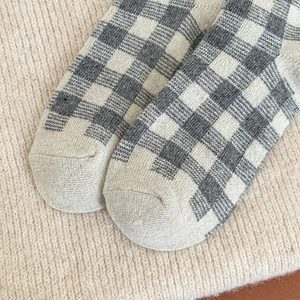 Detail of grey and white checkered knit socks with soft texture and warm fabric