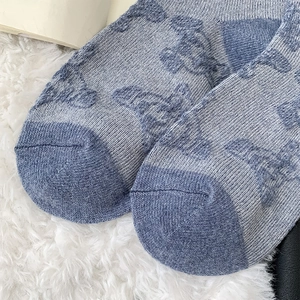Close-up of blue wool blend socks featuring floral jacquard and reinforced toe detail