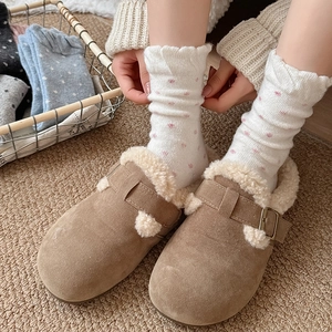 Detail of khaki suede house slippers with white faux fur lining and buckle decoration