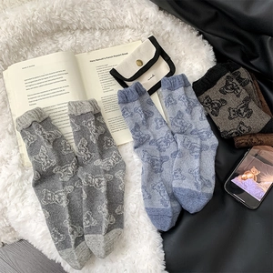 Detail showing wool blend socks with cute bear patterns on a soft plush background