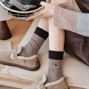 Detail of wool socks with puppy embroidery paired with warm fur-lined slippers