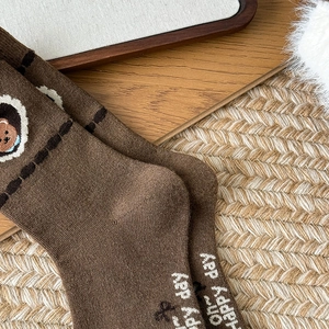 Close-up of brown wool socks featuring cute bear embroidery and Oh happy day lettering