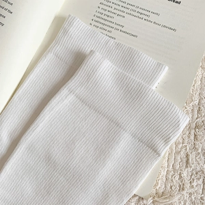 Detail of ribbed cuffs on white knitted calf socks with a soft cotton texture