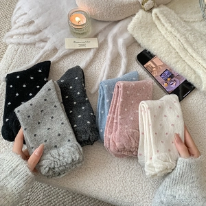 Close-up of thick wool crew socks with heart patterns in six pastel colors