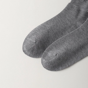 Détail de chaussettes en laine grise montrant la pointe renforcée et la maille côtelée