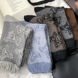 Detail of wool blend socks with vintage bear jacquard patterns and ribbed cuffs