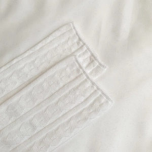 Detail of warm white cable knit texture and ribbed cuff on high-quality cotton socks