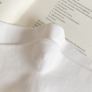 Close-up of white vertical ribbed knit fabric texture of the cotton calf socks