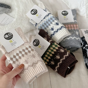 Dettaglio della trama a maglia di calze in lana Fair Isle con motivi nordici e fiocchi