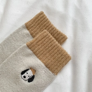 Close-up of Snoopy embroidery on thick wool-blend socks with brown ribbed cuffs