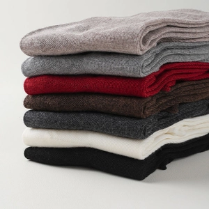 Gros plan de sept chaussettes en laine tricotée avec texture côtelée et finition douce