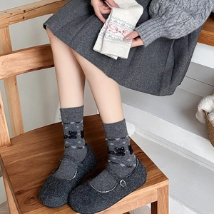 Detail of dark grey Mary Jane shoes with black cat pattern knitted crew socks