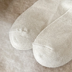Close-up of fine toe stitching and soft wool texture on Fair Isle style beige socks