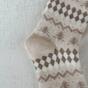 Dettaglio di calze di lana lavorate a maglia Fair Isle con motivi vintage e caldi