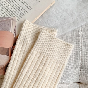 Detailed close-up of ribbed knit cream white calf socks with soft vertical texture