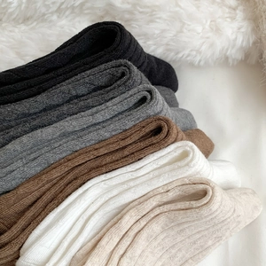 Detail showing cable knit texture and various solid colors of over-knee high socks