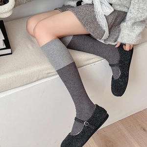 Detail of grey color-block wool stockings with vertical rib texture and Mary Jane shoes