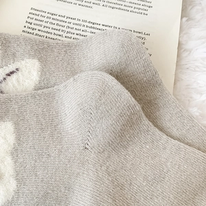 Detailed knit texture of thick grey wool socks with warm fleece details and soft finish