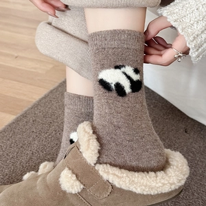Close-up of thick wool socks with cute panda pattern and cozy knit texture for winter