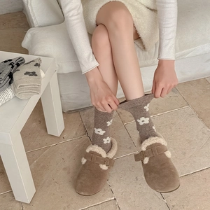 Detailed view of floral wool socks paired with warm sheepskin lined buckle mules shoes