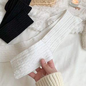 Close-up of cable knit patterns on over-the-knee socks for winter styling