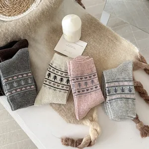 Detail of five pairs of wool blend socks with Fair Isle heart and pine tree patterns