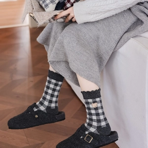 Detail of plaid socks with bear embroidery and wavy cuffs for a cozy winter style