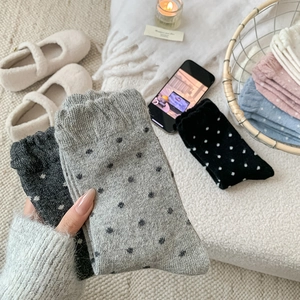 Detailed close-up of thick polka dot knit wool socks in various warm winter colors